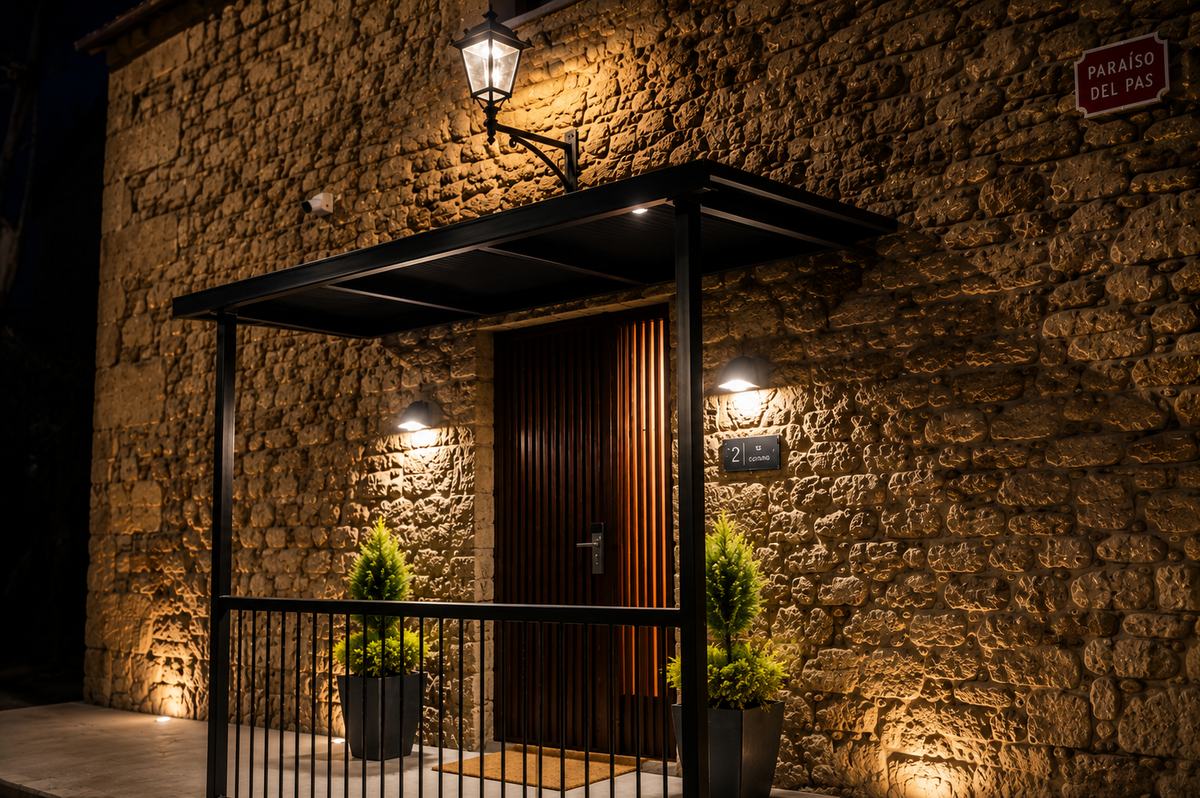 Fachada y entrada iluminada del hotel El Paraíso del Pas de noche